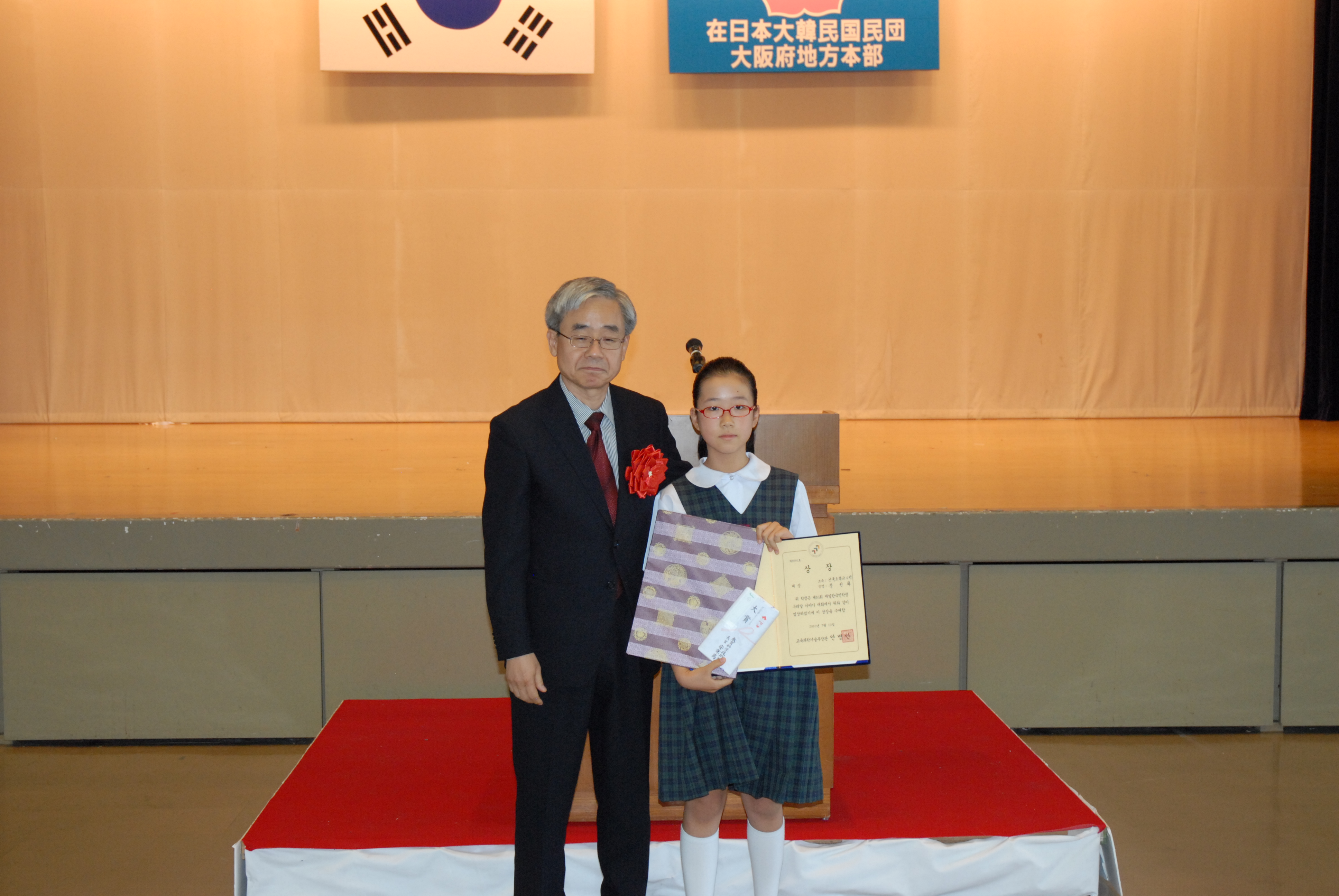 建国小学校6年 姜鮮華さんに駐日本大韓民国大使館の�｢優昌首席教育官から大賞が授与された。